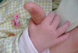 baby hand holding parent's thumb