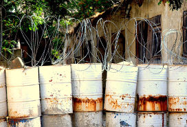 barrier made of barrels and barbed wire