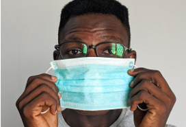 young black man putting on a mask