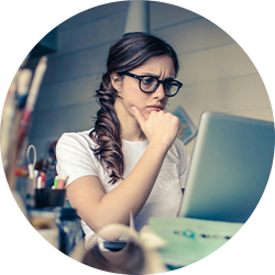 Person sitting at a desk using a laptop in a workspace
